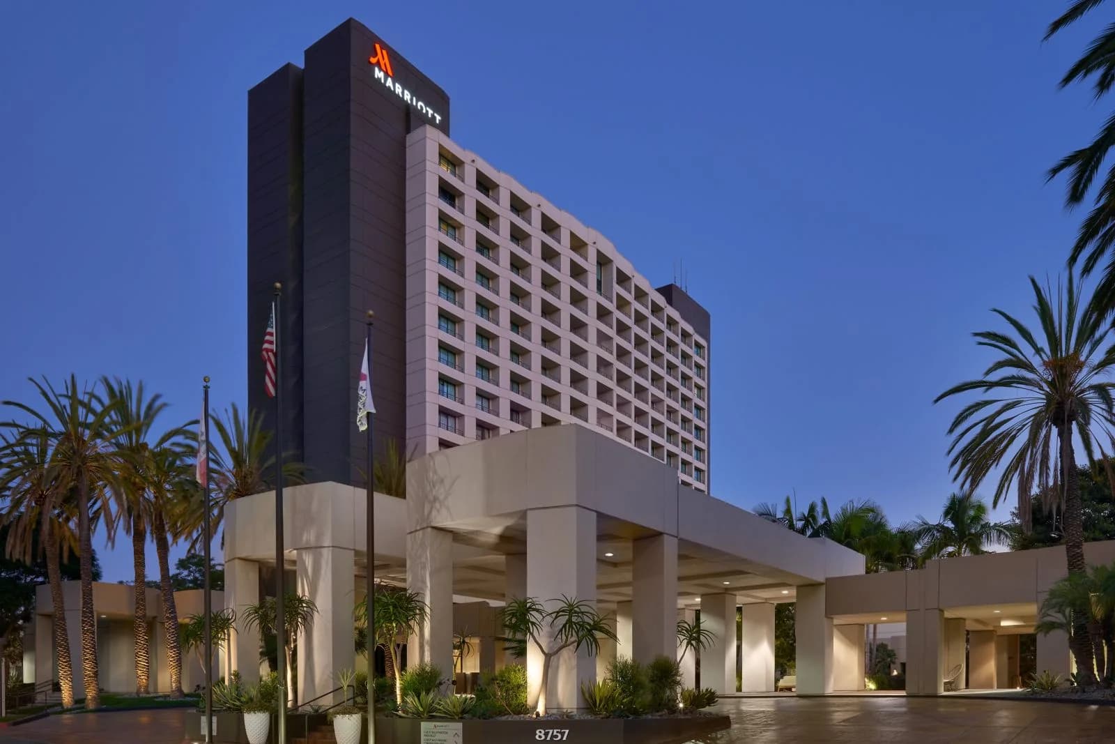 San Diego Marriott Mission Valley exterior at dusk, framed by palm trees