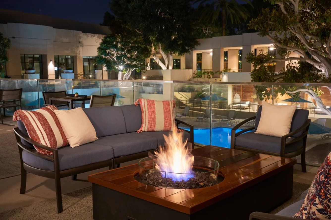 Firepit and lounge seating overlooking the illuminated pool at San Diego Marriott Mission Valley